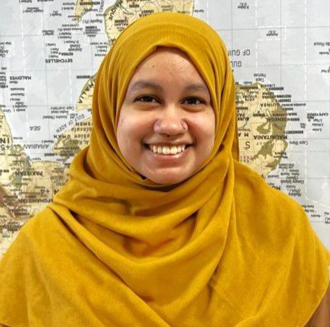 Image of Muslim woman with a smile wearing orange headscarf