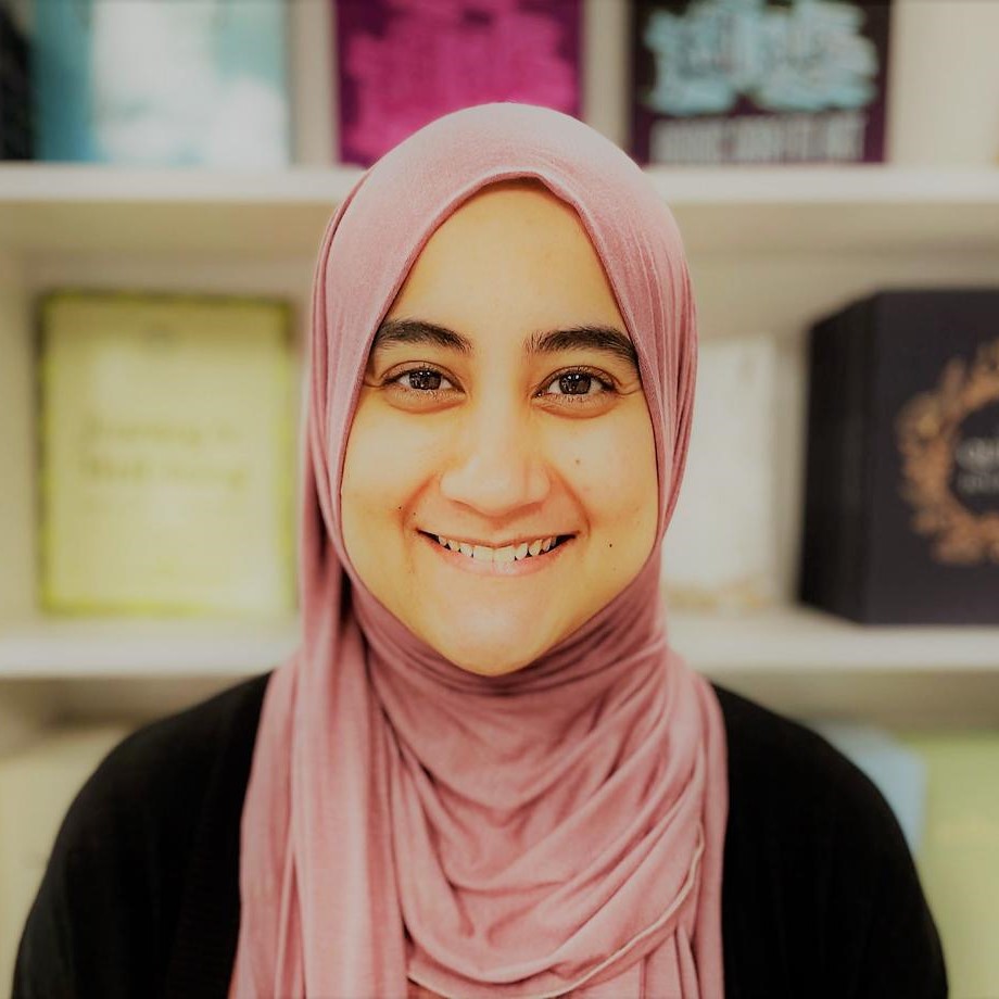 A profile photo of Anse Sana Mohiuddin, a Ribaat Academic Institute islamic sciences instructor and a family therapist, smiling. She is wearing pink hijab and black top.